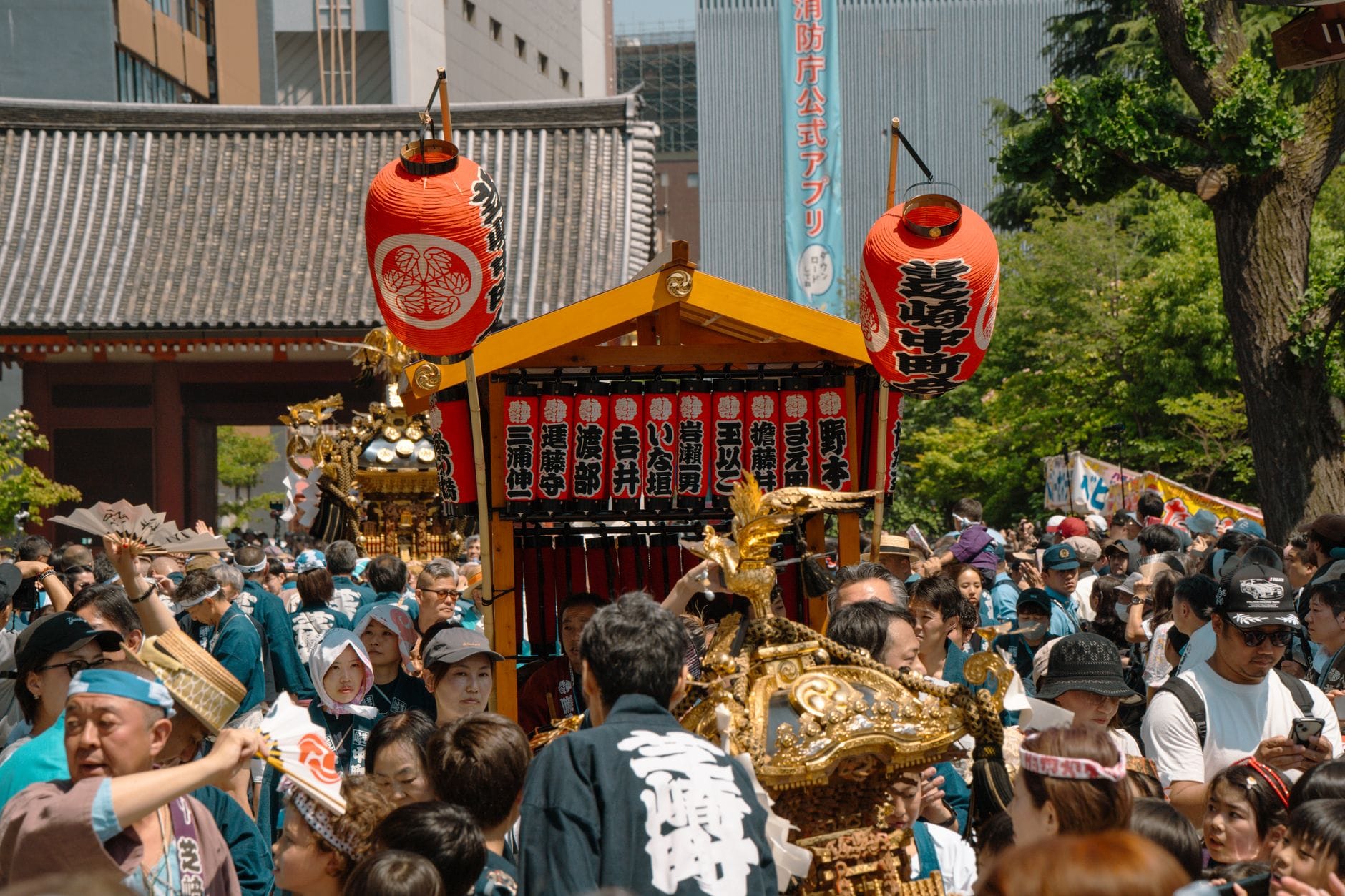 Tłum w Tokio niesie tradycyjne mikoshi podczas kolorowego matsuri Tłum w Tokio niesie tradycyjne mikoshi podczas kolorowego matsuri
