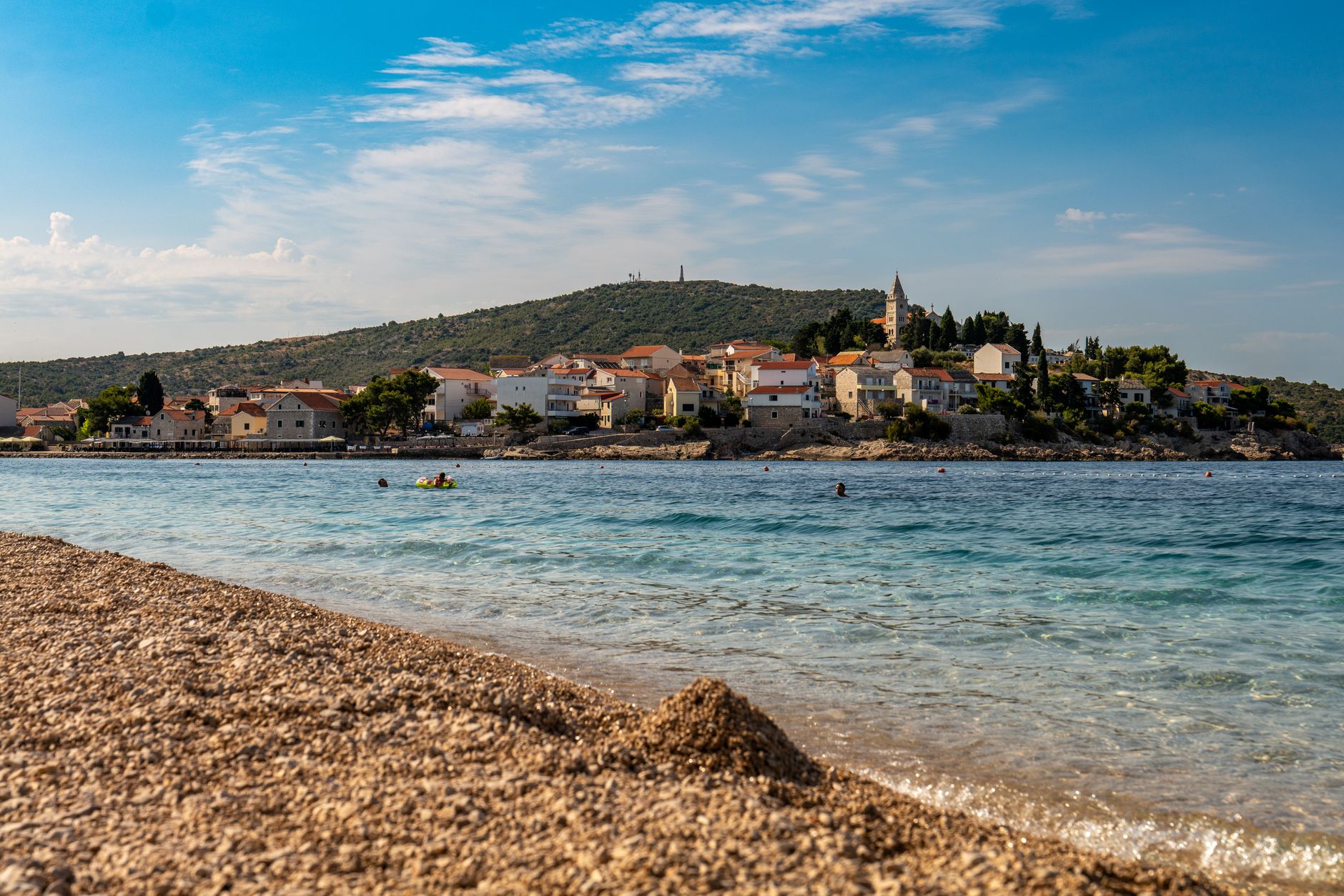 Plaża w Primošten w Chorwacji z turkusowym morzem i zabudową miasteczka